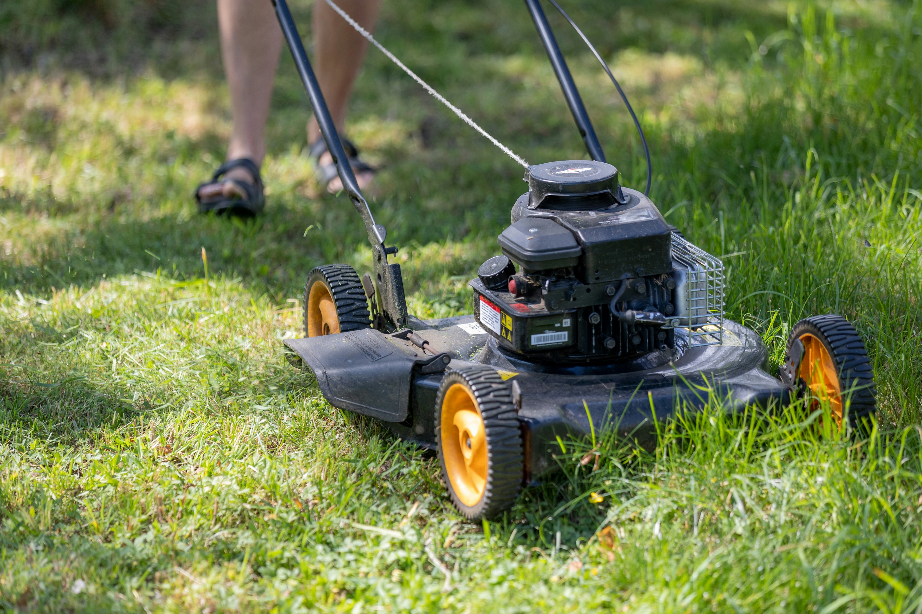 A real lawn mower cutting green grass outdoors