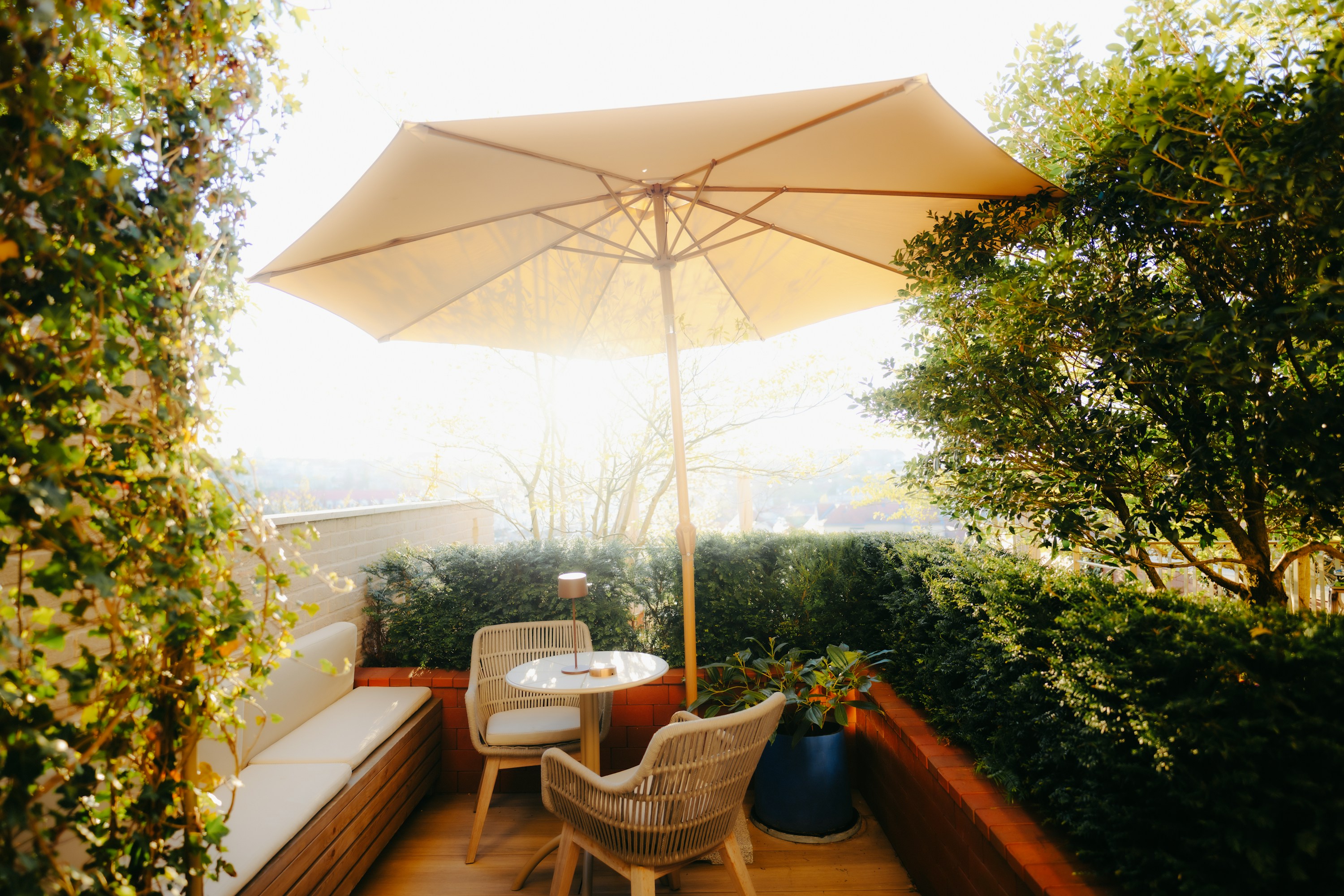 A real garden patio with an umbrella, table, and outdoor chairs